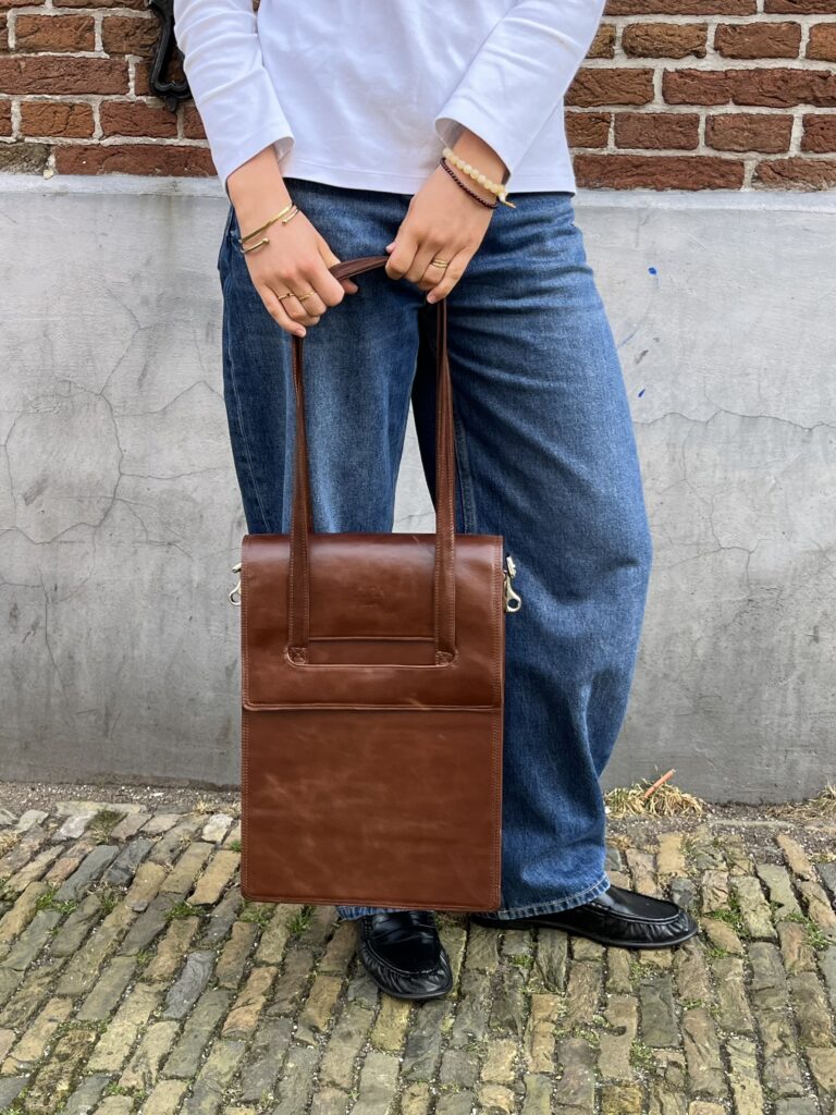 Persoon met leren tas en jeans